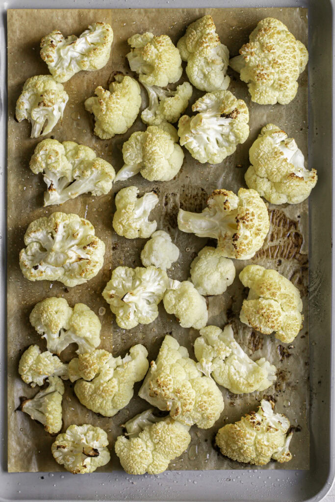 roasted cauliflower on a parchment-lined baking sheet.